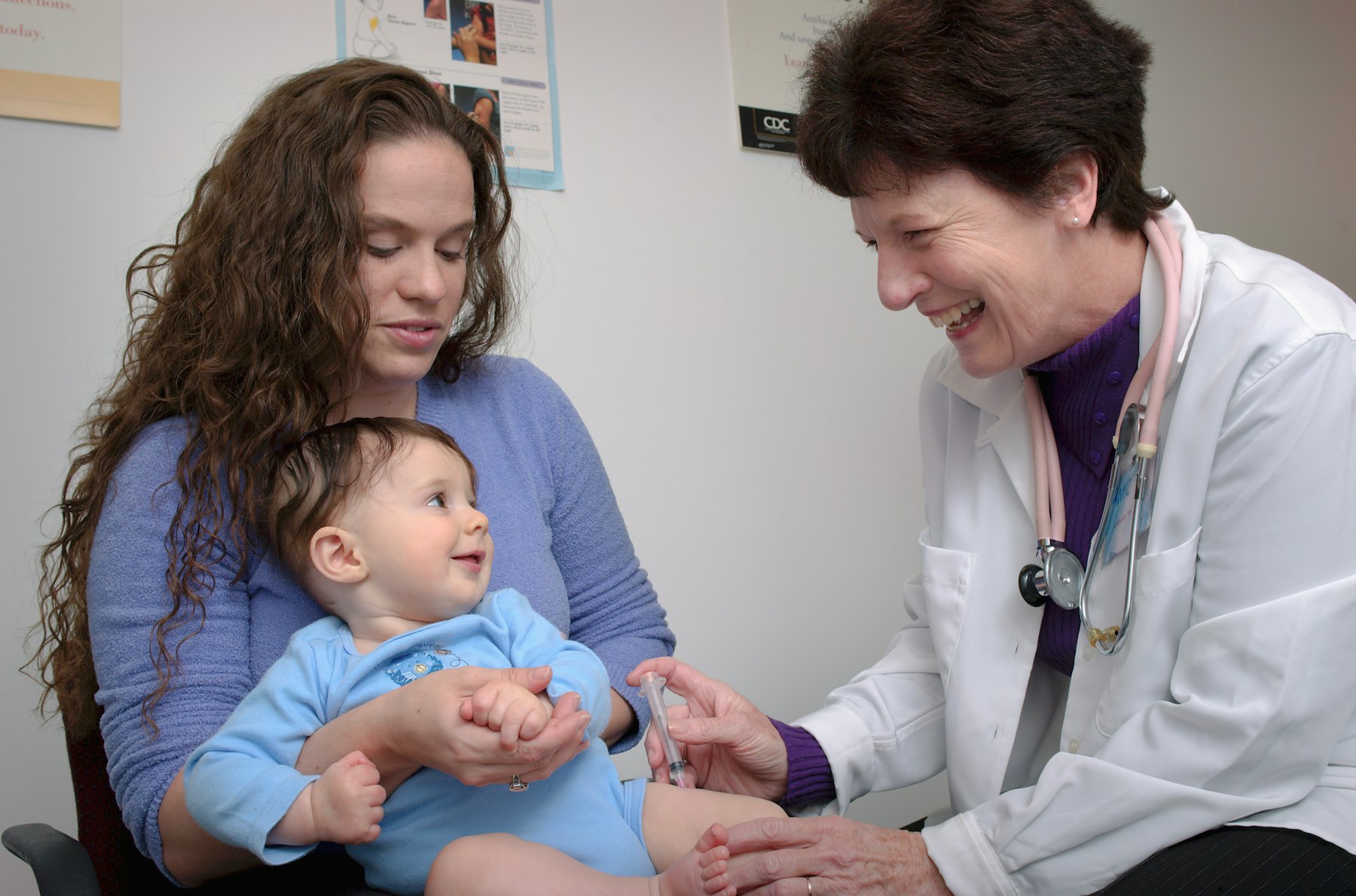 A doctor caring for a smiling baby
